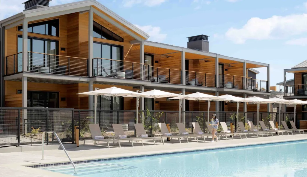 Appellation Hotels in Healdsburg, California, with a pool, lounge chairs, and a person carrying a drink.