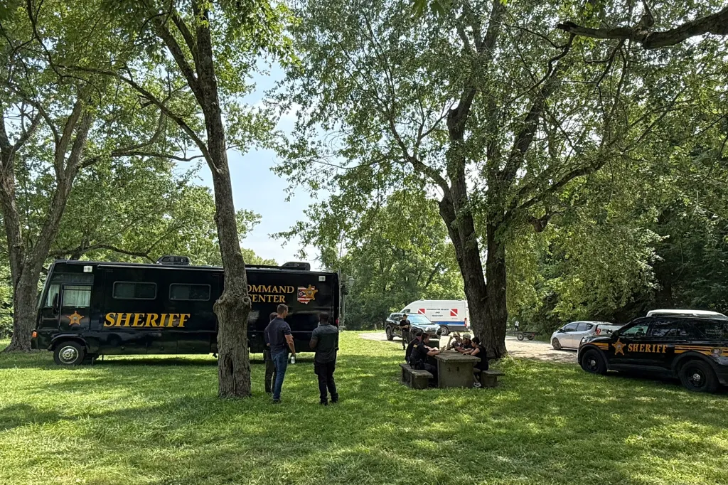 Sheriff's vehicles and officials gather at a staging area after a recovery operation in Powell, Ohio.