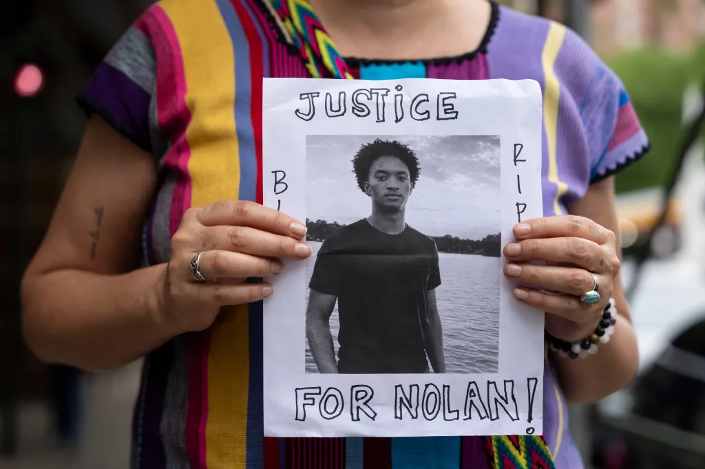 A person holds up a sign that says
