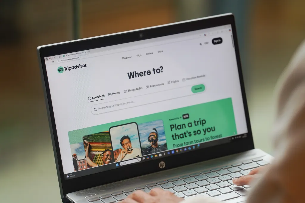 Photo illustration of a woman browsing the Tripadvisor website on her laptop.
