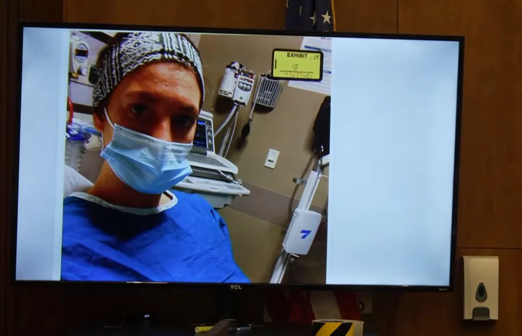 Photo of Lindsay Clancy hospitalized for suicidal thoughts, wearing a mask and blue gown.