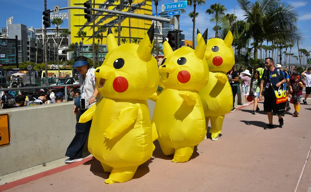 A pack of Comic-Con attendees wearing Pikachu costumes walk around the convention center.
