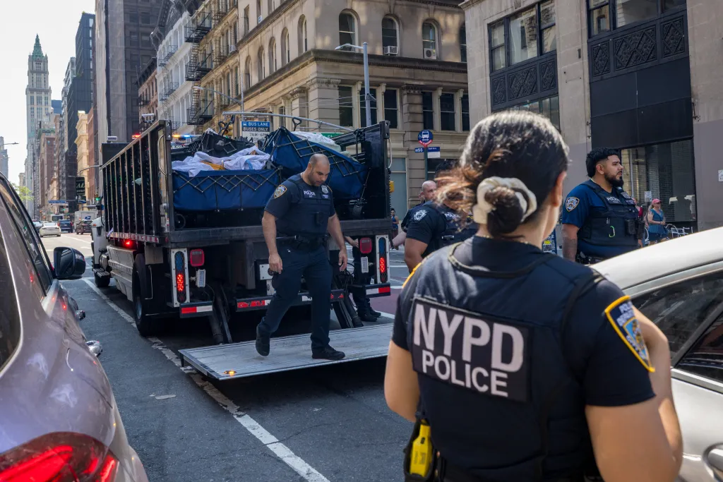 Police officers confiscating street vendor merchandise from a truck in lower Manhattan.