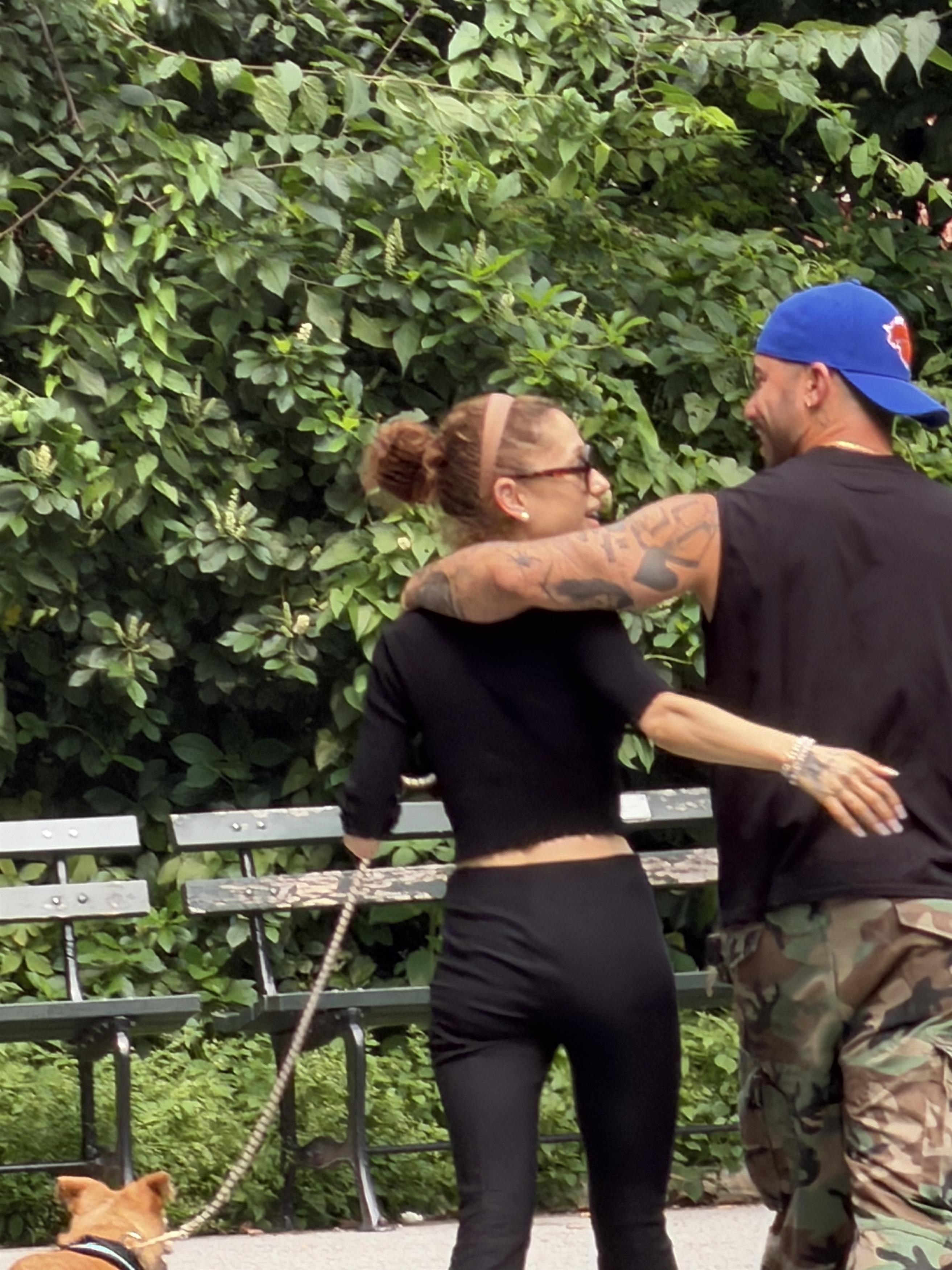 Ariana Grande and Ricky Alvarez embracing during a Central Park stroll with a dog on a leash.