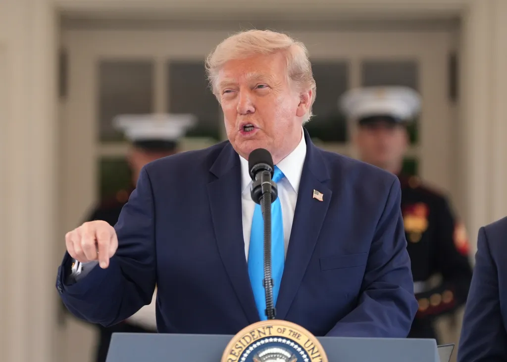 Donald Trump speaks at a podium with a microphone.