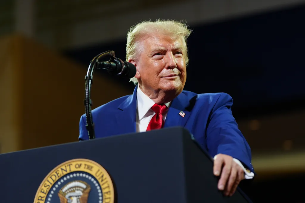Donald Trump speaking at a podium with the Seal of the President of the United States.