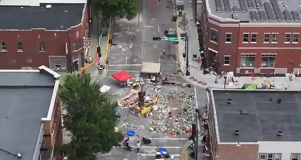 Aerial view of Williamson Street blocked by a protest with makeshift shelters and memorial items.