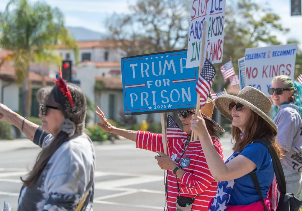 Anti-Trump protestors holding signs that read 
