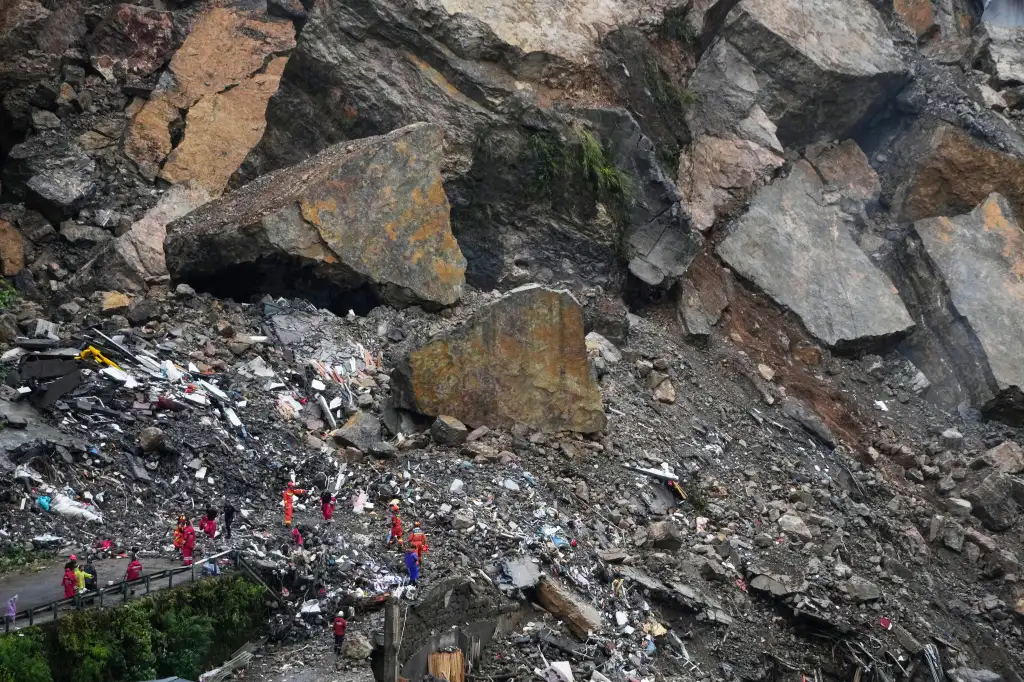 Rescuers searching for survivors in debris from a landslide in Pengshui County, China.