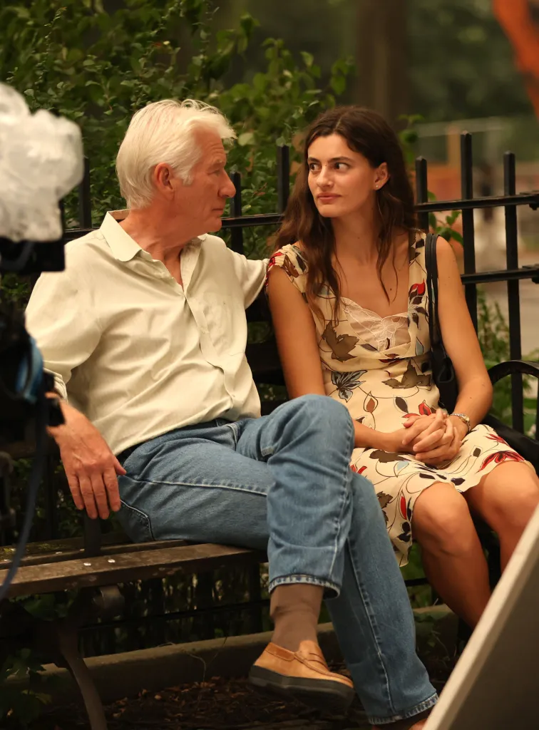 Richard Gere and Diana Silvers sitting on a bench while filming 