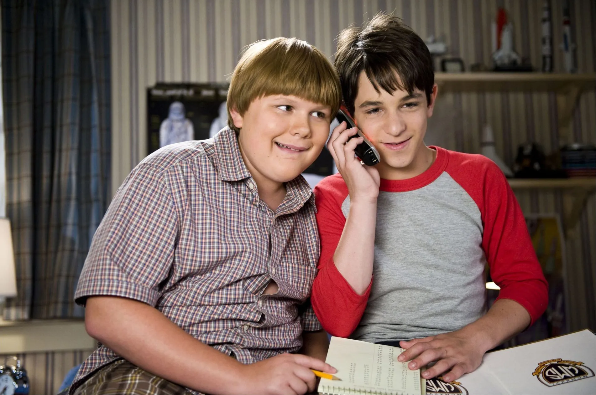 Robert Capron as Rowley Jefferson and Zachary Gordon listening in on a phone call.