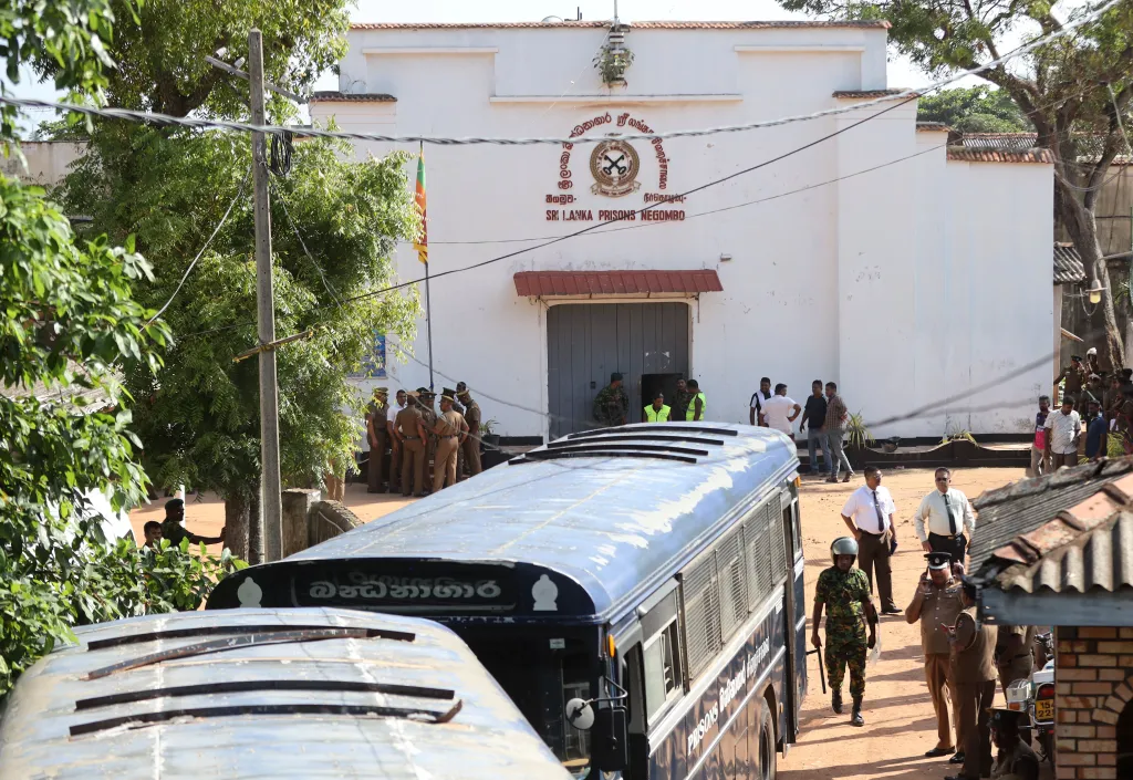 Security personnel escorting prisoners to a bus at Negombo Prison after a riot.