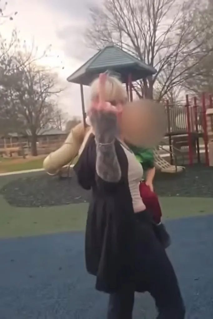 Shiloh Hendrix flips a middle finger to the camera, with a blurred child next to her on a playground