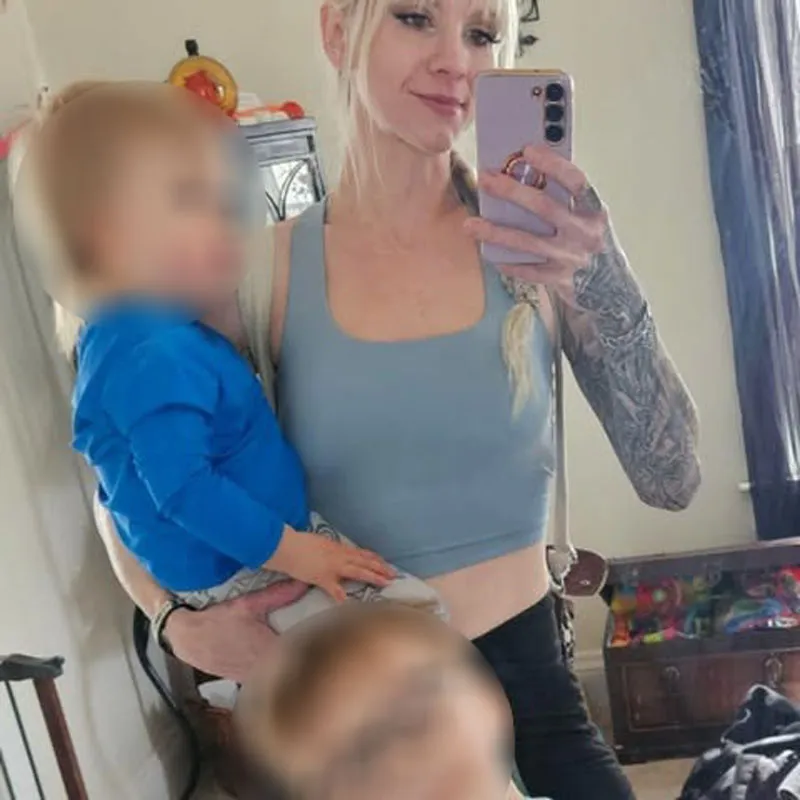 Shiloh Hendrix holding a child in mirror selfie