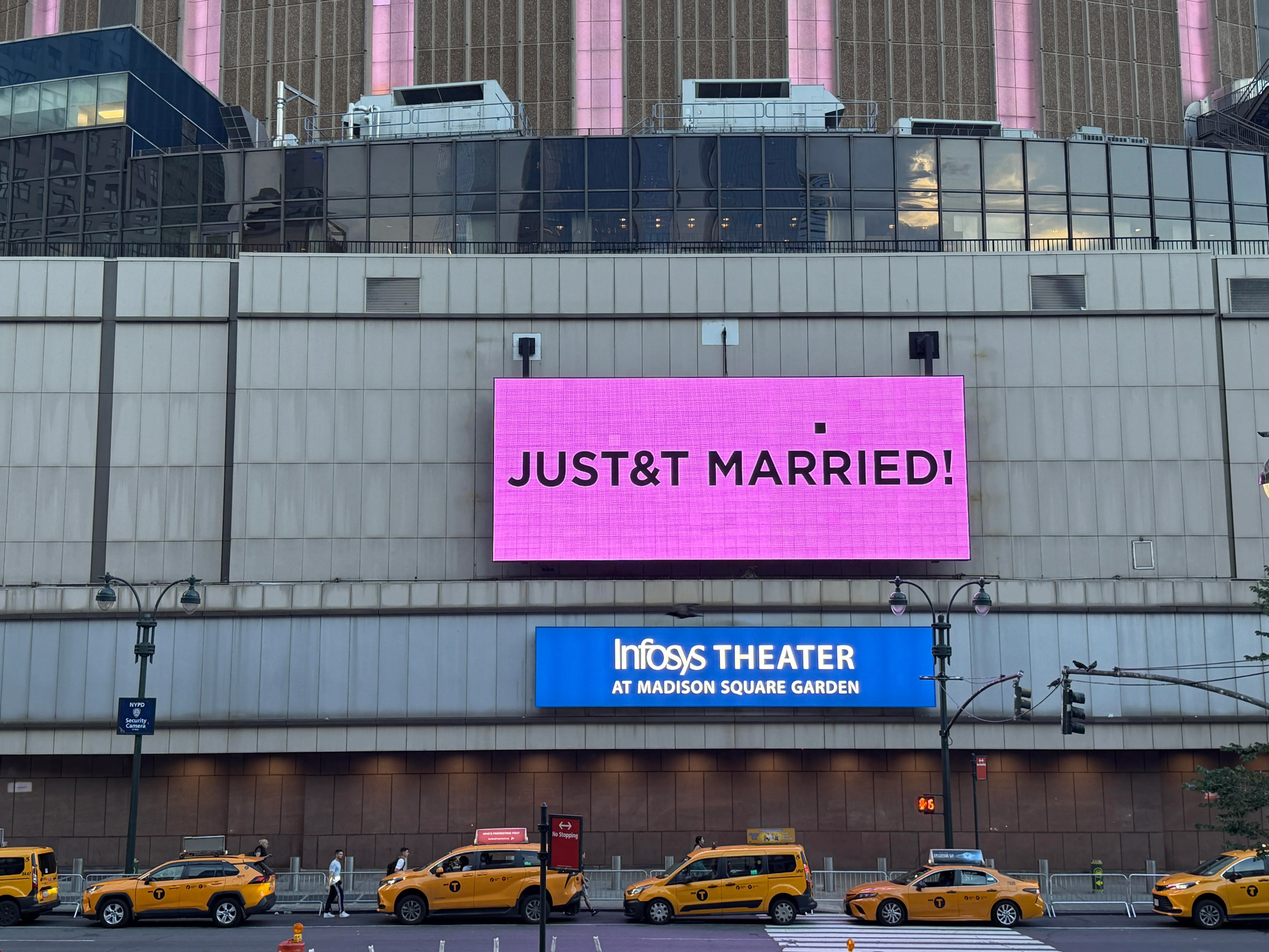 A large pink LED sign on Madison Square Garden reads 