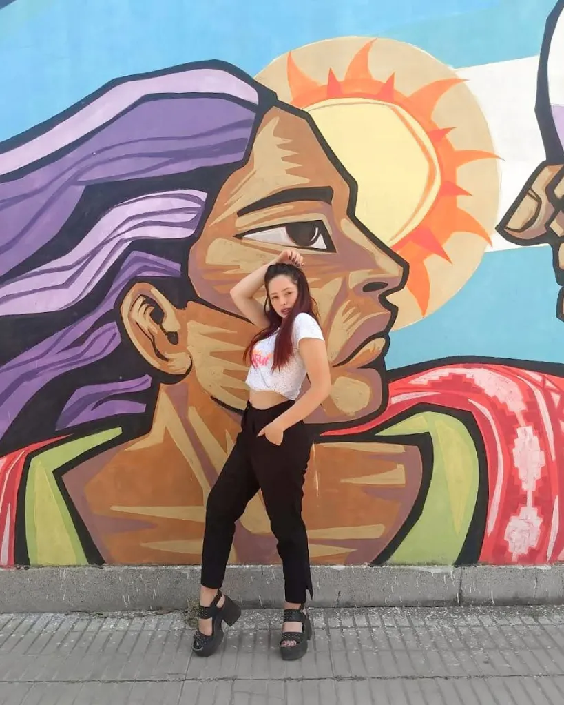 Sofía Devries posing in front of a colorful mural.
