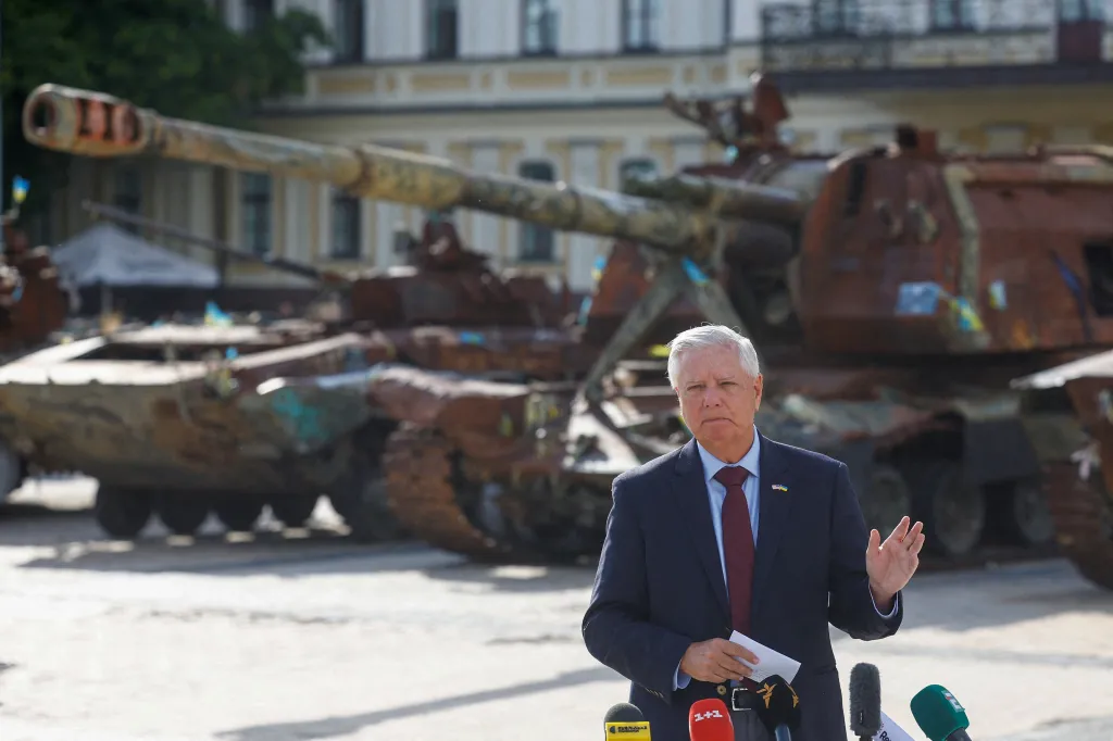 U.S. Senator Lindsey Graham speaking to the media in Kyiv with damaged tanks in the background.