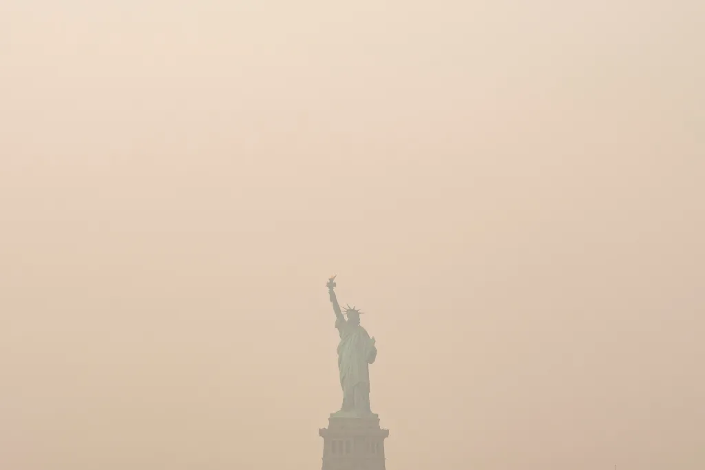 The Statue of Liberty is photographed from the Staten Island Ferry as smoke from wildfires blankets the sky, Thursday, July 16, 2026, in New York.