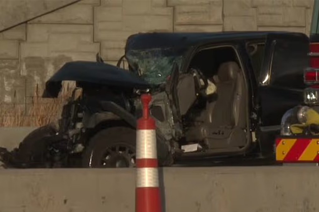 Black GMC pickup truck with heavy front-end damage and a shattered windshield after colliding with a Ford F-450.