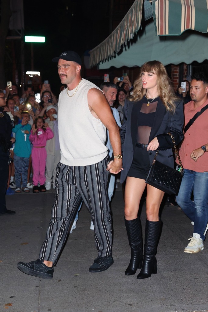 Taylor Swift and Travis Kelce holding hands while leaving Lucali Pizza in Brooklyn.