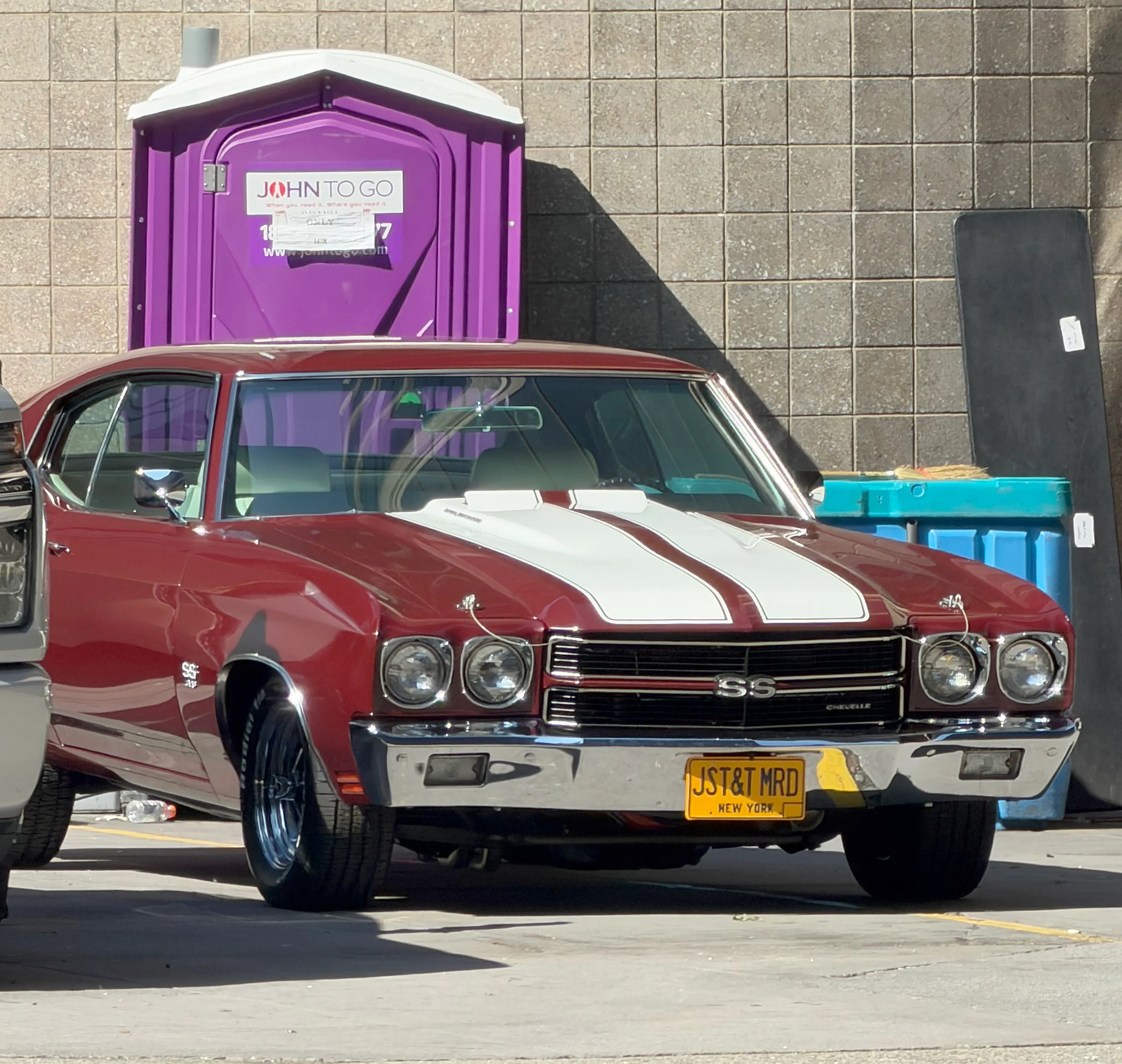 A maroon Chevrolet Chevelle with white racing stripes and a license plate reading