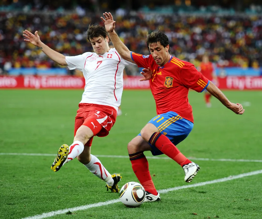 Switzerland's Tranquillo Barnetta blocking a cross from Spain's Joan Capdevila during a soccer match.