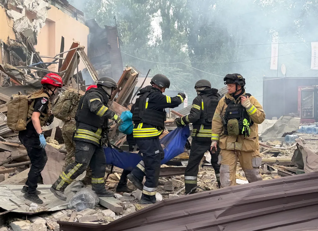 Ukrainian rescuers carry an injured woman from a residential area in Zaporizhzhia following a Russian airstrike.