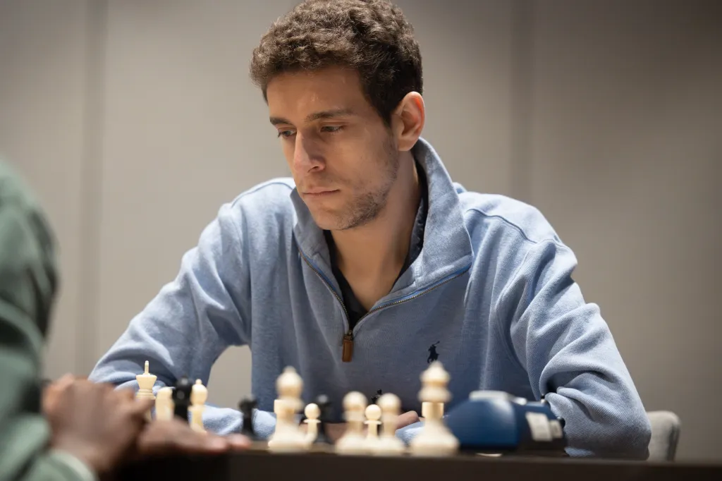 This undated photo released by Charlotte Chess Center shows Daniel Naroditsky playing chess on the board.