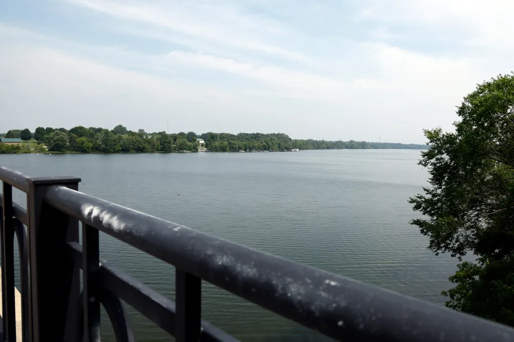 A view of the Scioto River from the Fred L, Stults Bridge, with trees and buildings visible on the opposite bank.