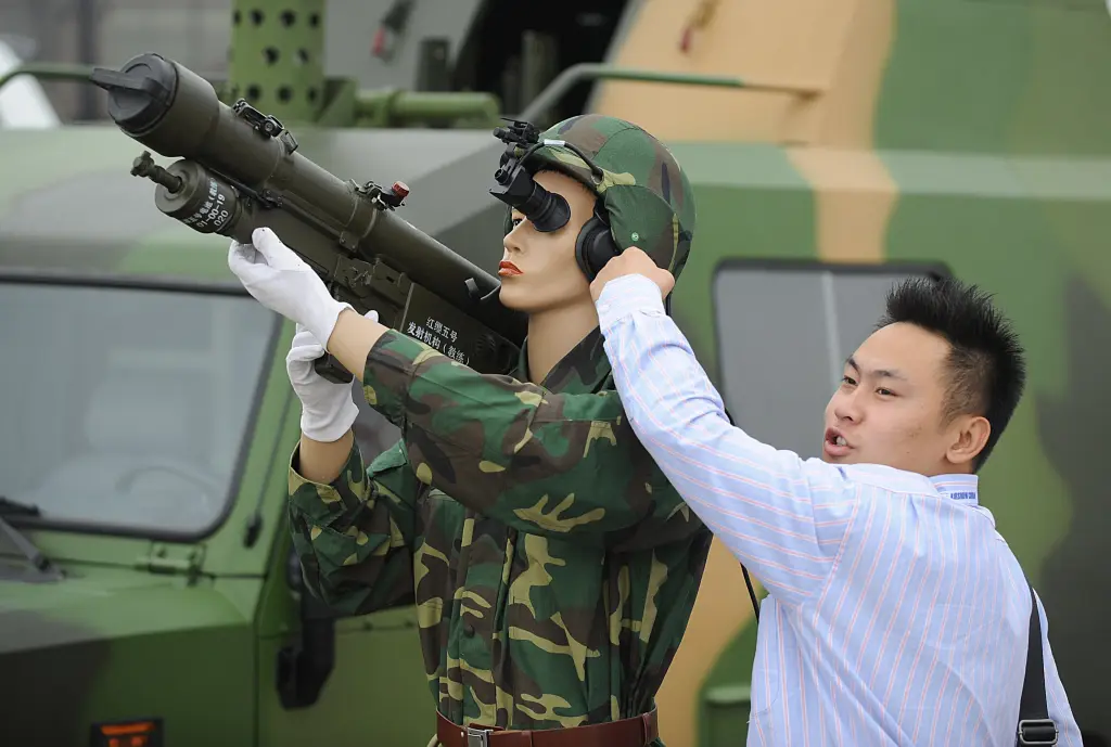 A Chinese tourist poses next to a display of a soldier holding a missile launcher at the China Airshow in Zhuhai on Nov. 4, 2008.