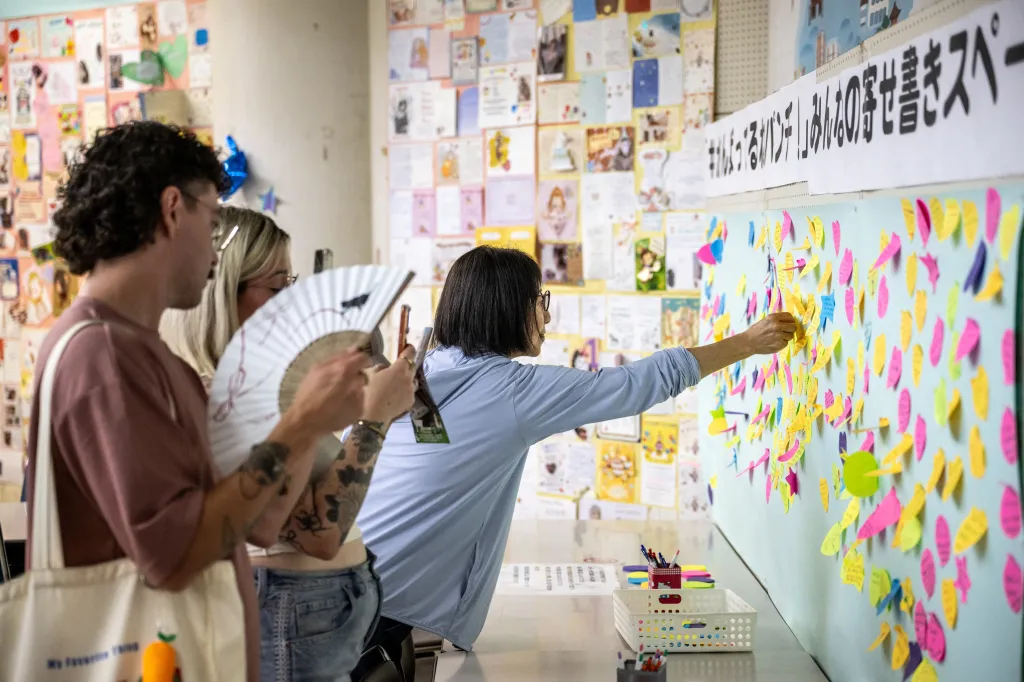 Visitors place birthday messages on a wall for a monkey named Punch.