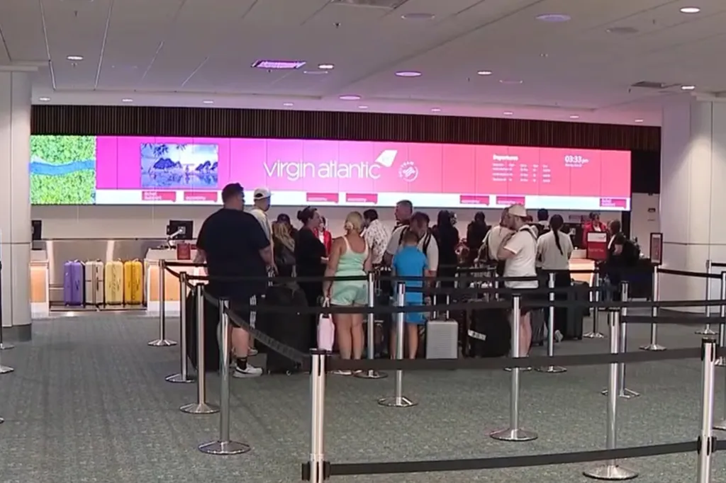 Passengers wait online at a Virgin Atlantic desk at Orlando International Airport.