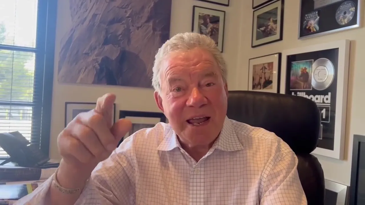 William Shatner in an office, pointing and speaking.
