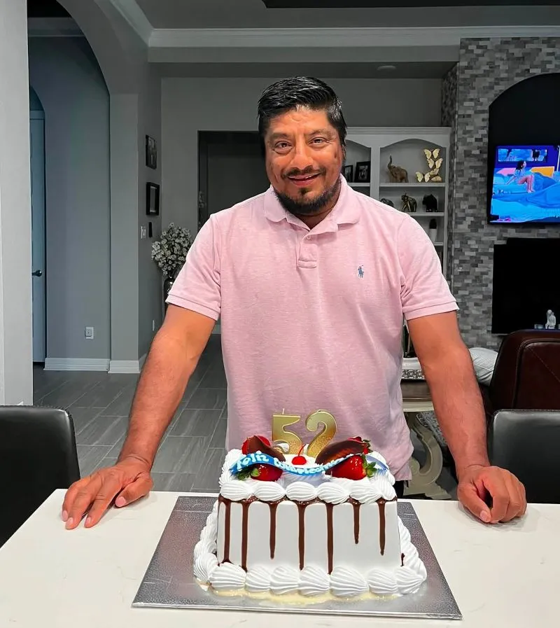 Lorenzo Salgado Araujo standing behind a birthday cake with candles shaped as the number 52.
