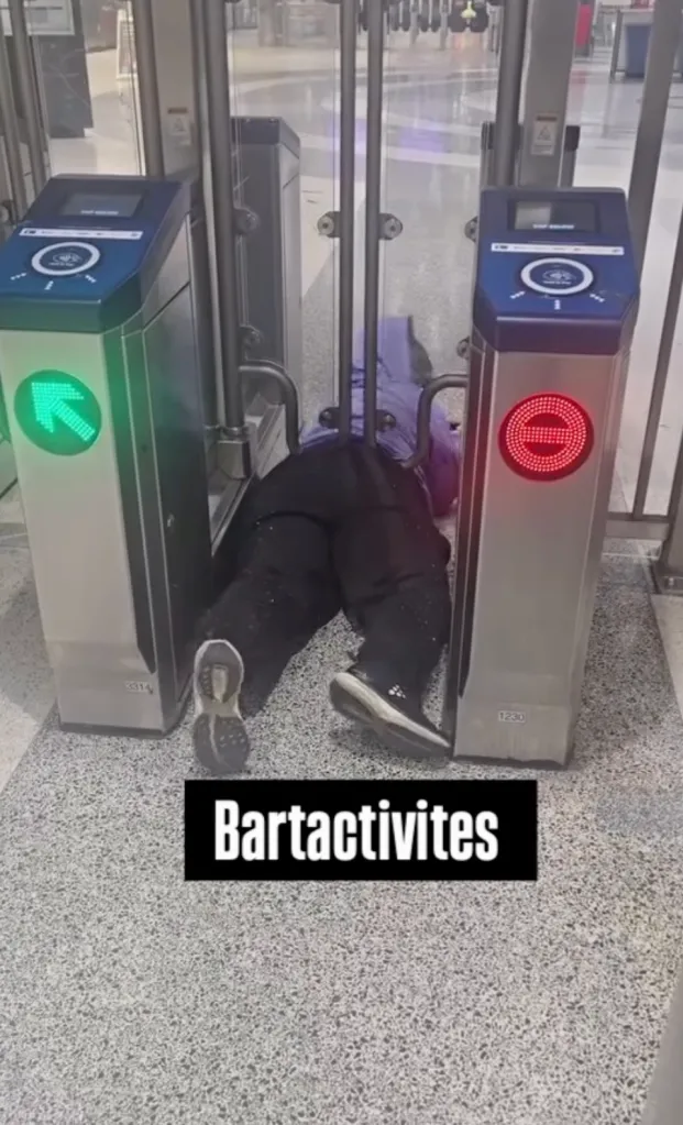 A person stuck under a BART entry gate.