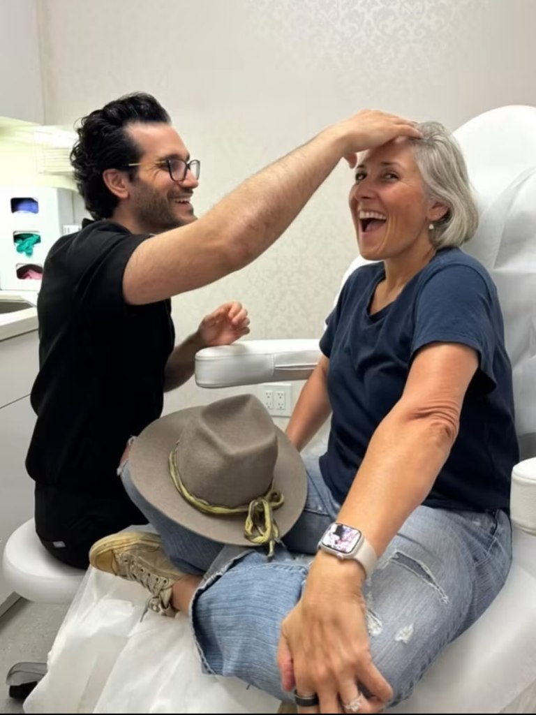 Ricki Lake laughing as a doctor touches her forehead.