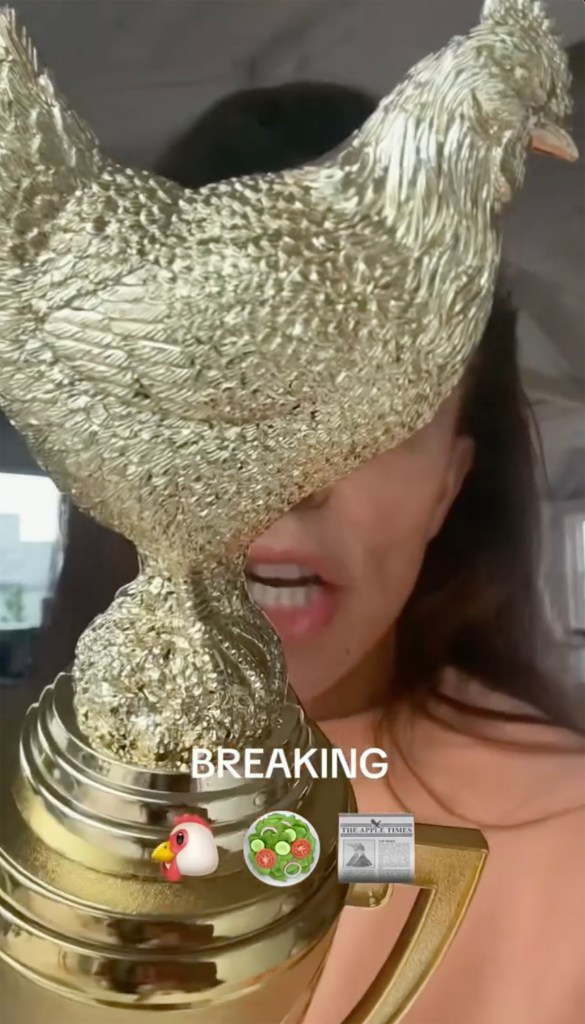 Bethenny Frankel holding a gold chicken trophy with 
