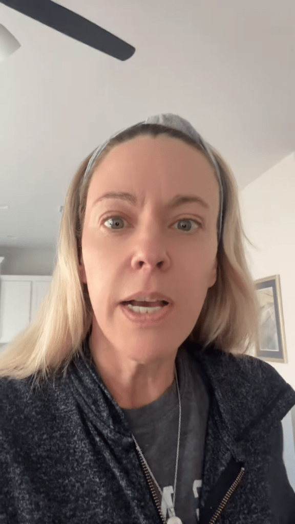 Kate Gosselin looking directly at the camera with her mouth slightly open.