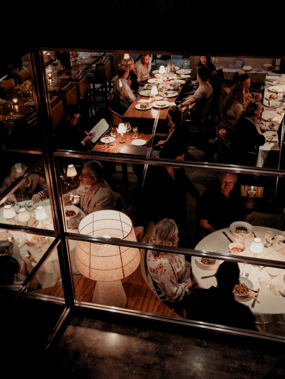 People dining at a restaurant, viewed from an upper level.