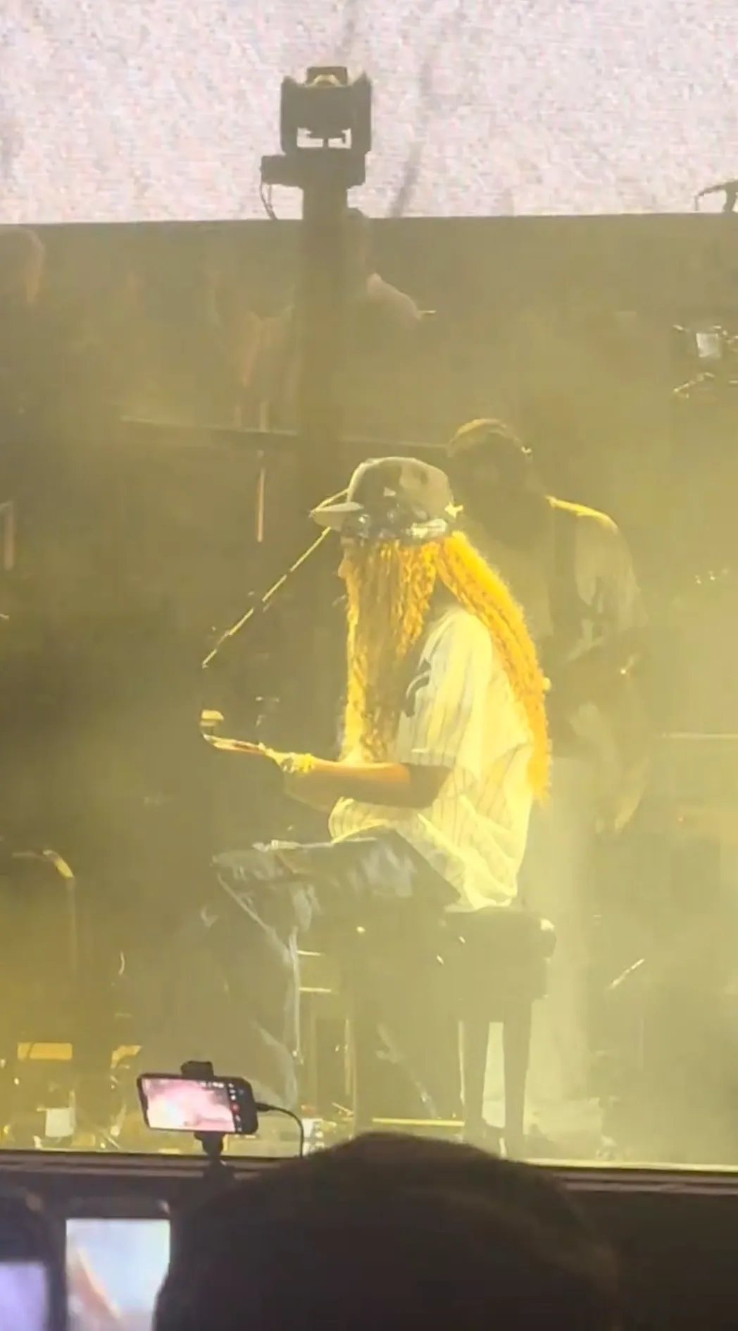Blue Ivy Carter playing the piano on stage, illuminated by yellow stage lights.