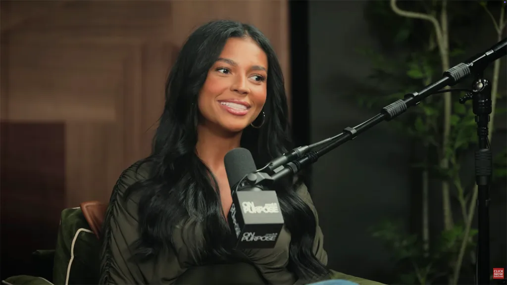 Layla Taylor smiling next to a microphone.