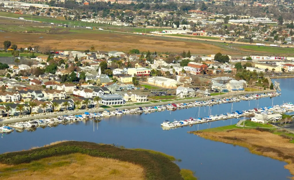 Aerial view of Suisun City's waterfront, with a marina full of boats, historic downtown, and residential areas.