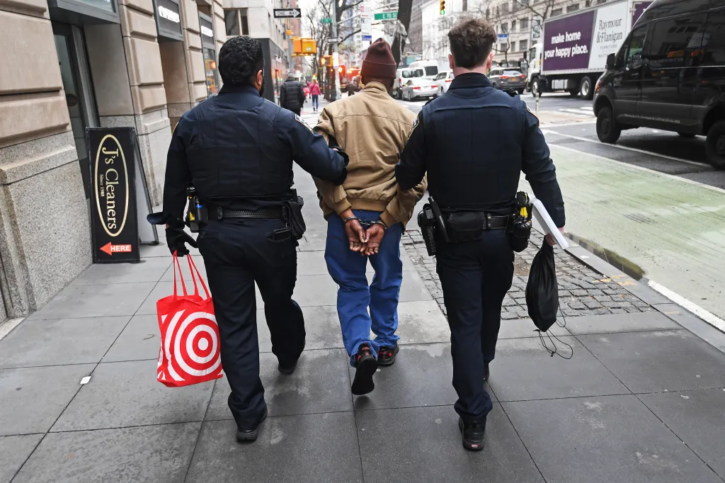 Two police officers arrest a man for shoplifting from a Target store.