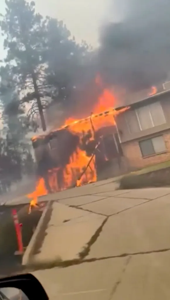 House in Northwest Spokane engulfed in flames and dark smoke.
