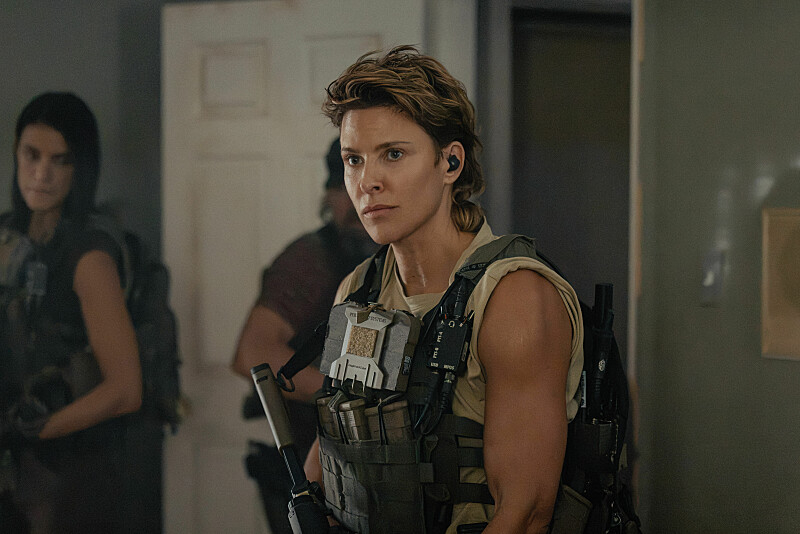 Jill Wagner, in a khaki tank top and military vest, as Bobby in Lioness, episode 2, season 3.