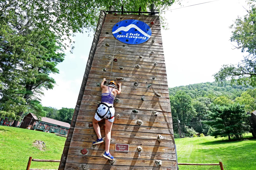 Anna Blue climbs a rock wall at Camp Getaway.