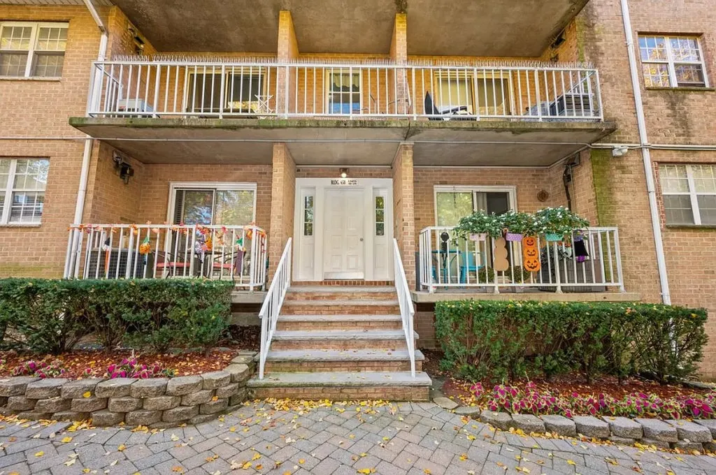 Building entrance with brick stairs and Halloween decorations on the balconies.