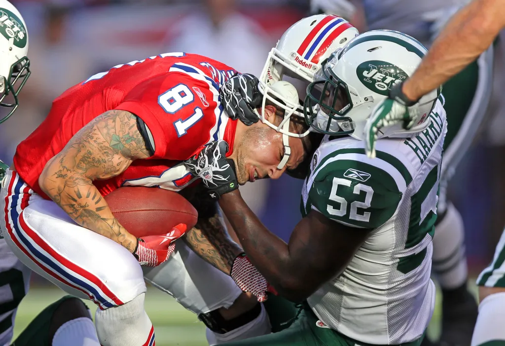 David Harris of the New York Jets tackling Aaron Hernandez of the New England Patriots, knocking off his helmet.
