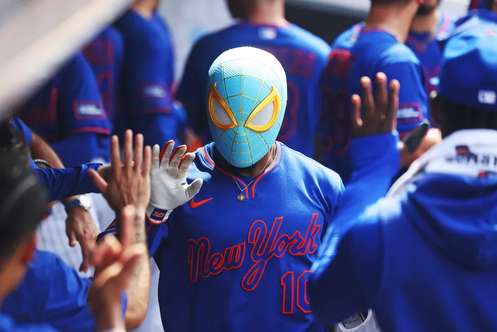 Marcus Semien of the New York Mets wearing a Spider-Man mask in the dugout.