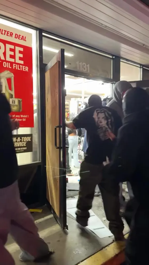 People entering a ransacked AutoZone during a street takeover.